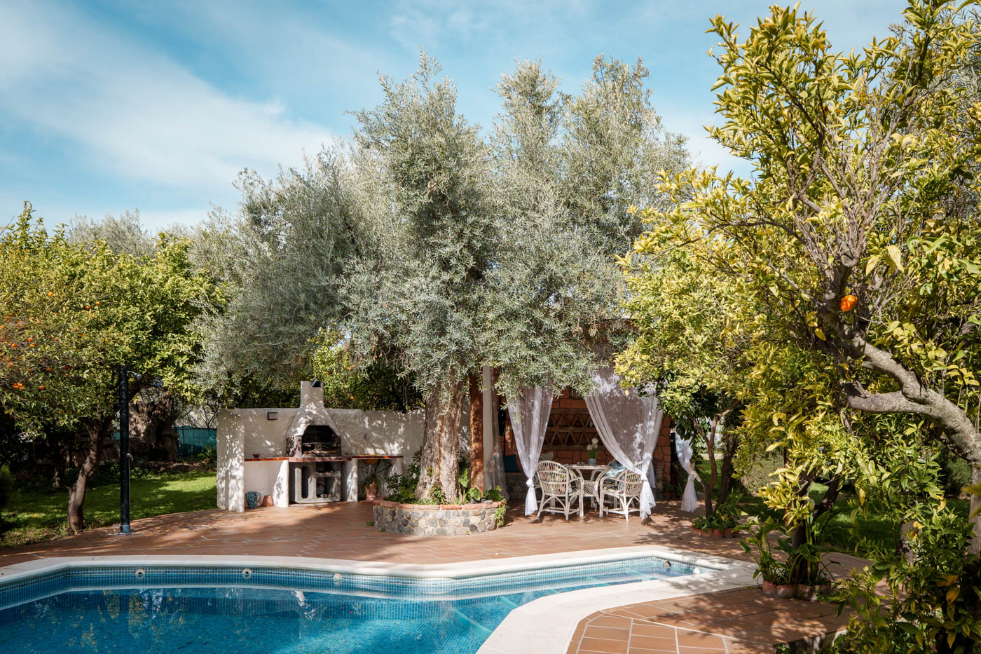 La piscina está junto a porche y casa