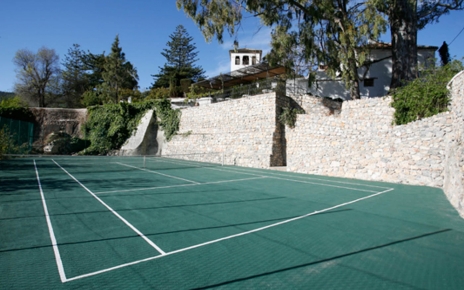 Cancha de tenis y casa a la derecha