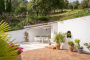 Zona amueblada exterior con toldo junto a piscina