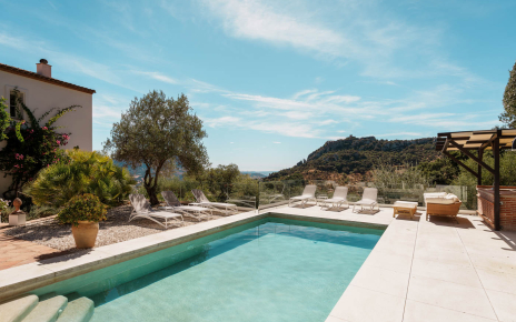 Pool area next to the house with different furnished areas