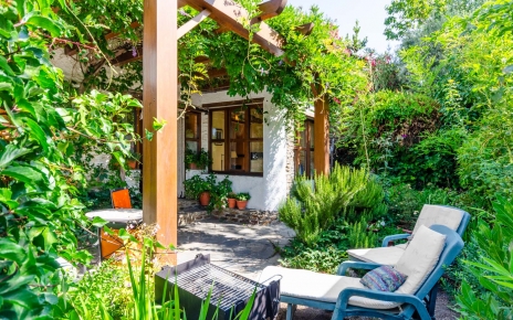 Pequeña zona ajardinada con 2 tumbonas y barbacoa