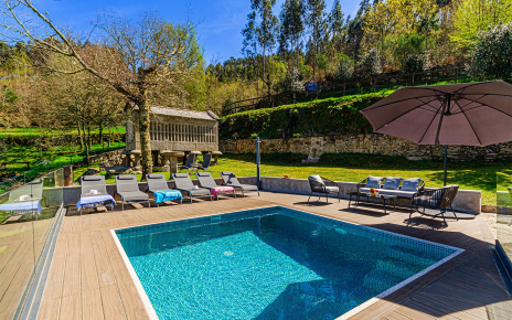 Casa con piscina rodeada de arboleda y jardines