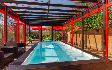 Piscina calefactada y tumbonas al fondo